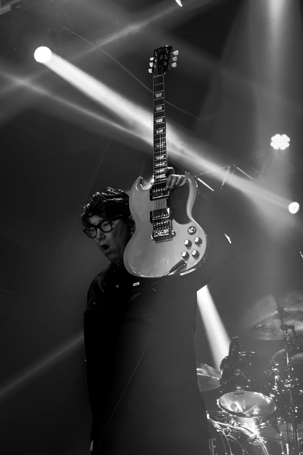 Guitarist raising a guitar to the lights at a live show
